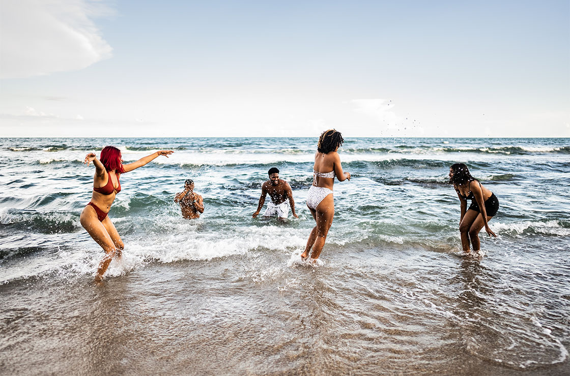 Young friends playing in the water at the beach